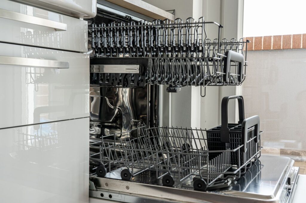 Open dishwasher with clean racks in a modern kitchen, representing dishwasher repair and same-day appliance service in Frisco TX
