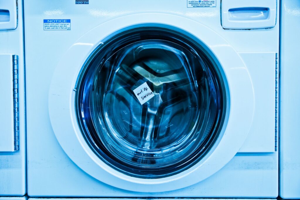 Close-up of a washing machine drum with an out-of-service notice, illustrating common washer error codes