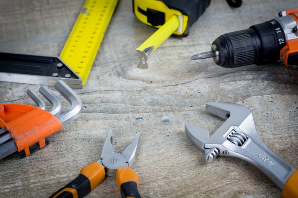 DIY repair tools laid out on wooden surface representing homeowner troubleshooting and diagnostic work